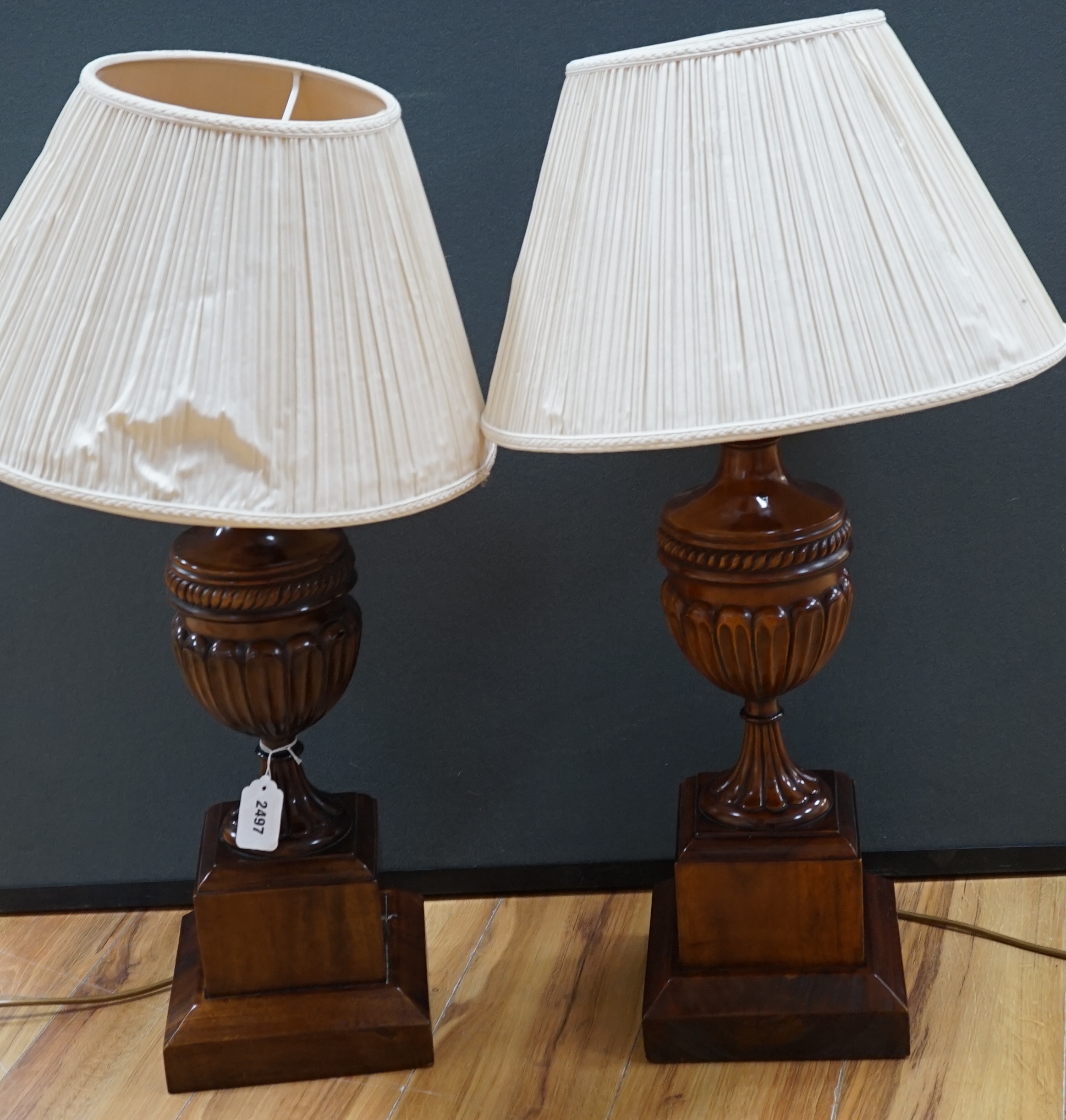 A pair of George III style mahogany carved urn table lamps with shades, 74cm high overall